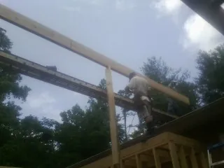 Carpenter setting a ridge beam over a new addition frame — Ice Dam Removal by Roofing Brothers in Summit Argo
