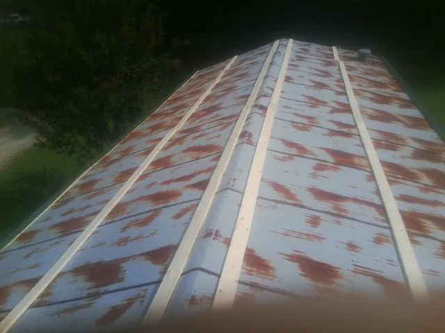 Rusted metal roof panels with new wood purlins before replacement — Storm Damage Roof Repair in Summit Argo by Roofing Brothers