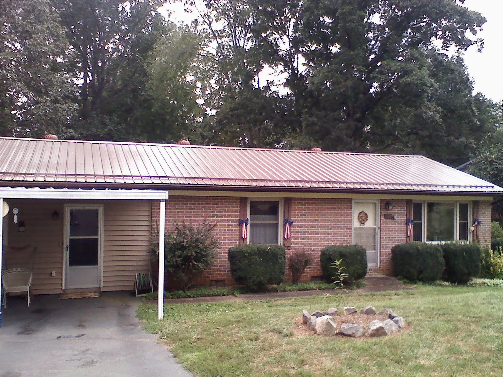 Bronze metal roof and carport on a brick ranch home — Roof Repair work by our crew in Summit Argo